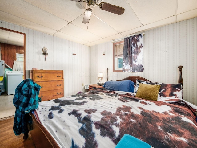 775 Koebel Ave, Columbus, OH 43207 - bedroom with washer / clothes dryer, wood finished floors, gas water heater, ceiling fan, and a drop ceiling