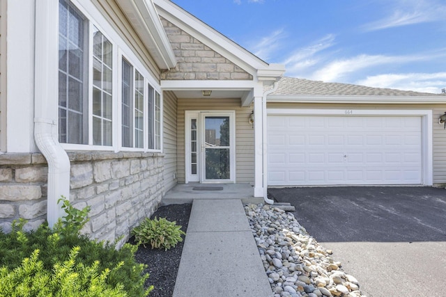 664 Bideford Ave Unit 11B, Blacklick, OH 43004 - doorway to property featuring asphalt driveway, stone siding, and an attached garage