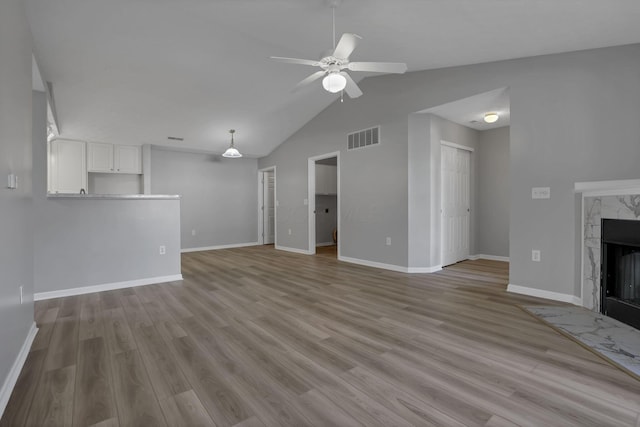 664 Bideford Ave Unit 11B, Blacklick, OH 43004 - unfurnished living room with ceiling fan, vaulted ceiling, a high end fireplace, and wood finished floors