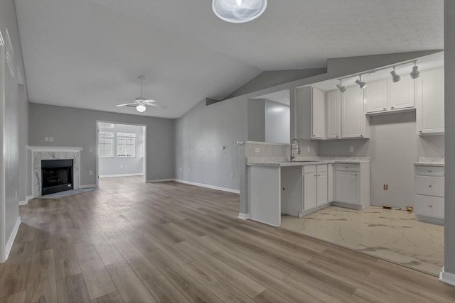 664 Bideford Ave Unit 11B, Blacklick, OH 43004 - kitchen with light wood-style flooring, vaulted ceiling, a ceiling fan, open floor plan, and a high end fireplace
