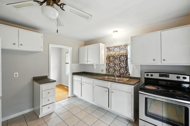 1193 Marble Dr, Columbus, OH 43227 - kitchen featuring electric stove, ceiling fan, dark countertops, light tile patterned flooring, and white cabinetry