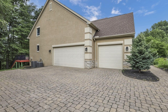 2773 Eleanor Way, Lewis Center, OH 43035 - view of home's exterior featuring decorative driveway, stone siding, stucco siding, an attached garage, and a deck