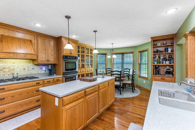 6247 State Route 61, Shelby, OH 44875 - kitchen featuring stainless steel appliances, custom range hood, light countertops, light wood-style floors, and tasteful backsplash