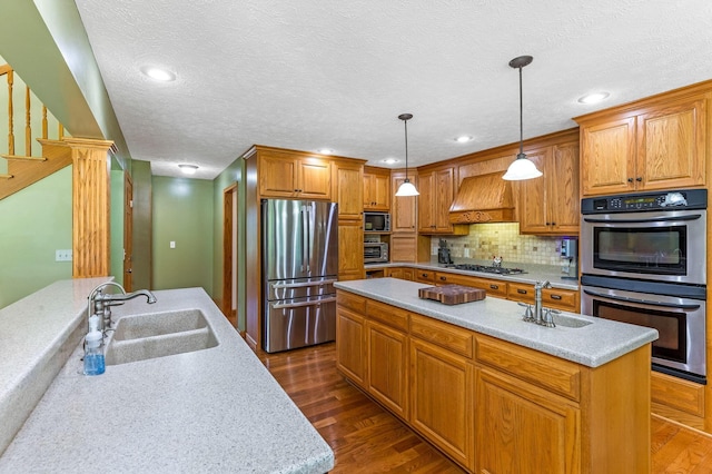 6247 State Route 61, Shelby, OH 44875 - kitchen with appliances with stainless steel finishes, premium range hood, dark wood-style flooring, a center island with sink, and decorative backsplash