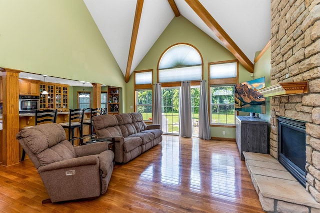 6247 State Route 61, Shelby, OH 44875 - living area featuring decorative columns, wood-type flooring, high vaulted ceiling, a fireplace, and beamed ceiling