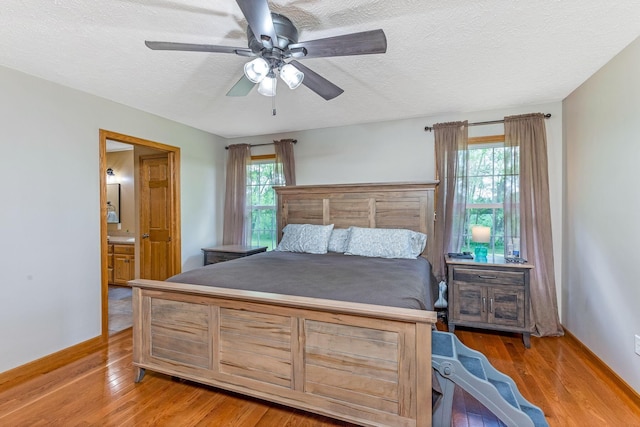 6247 State Route 61, Shelby, OH 44875 - bedroom with multiple windows, a textured ceiling, wood finished floors, ceiling fan, and ensuite bath