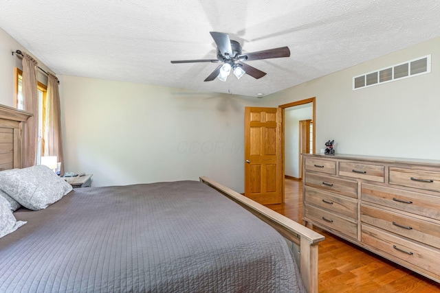 6247 State Route 61, Shelby, OH 44875 - bedroom with light wood-type flooring, a textured ceiling, and ceiling fan