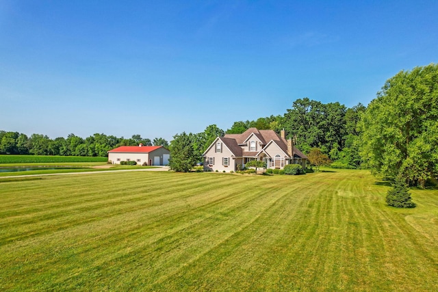 6247 State Route 61, Shelby, OH 44875 - view of front of home with a front yard, a water view, a chimney, an outdoor structure, and a detached garage
