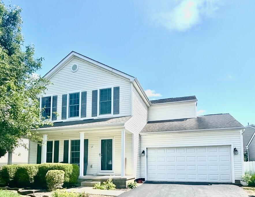 545 Thistleview Dr, Lewis Center, OH 43035 - traditional-style home featuring a porch, an attached garage, and asphalt driveway