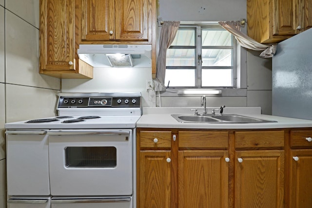 141 Dunmore Rd, Circleville, OH 43113 - kitchen featuring white electric stove, under cabinet range hood, light countertops, and brown cabinets