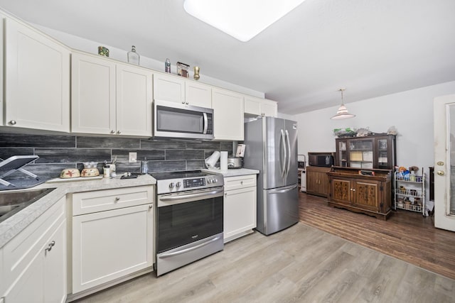 777 Mayme Moore Pl, Columbus, OH 43203 - kitchen featuring stainless steel appliances, backsplash, light countertops, light wood-style flooring, and white cabinets