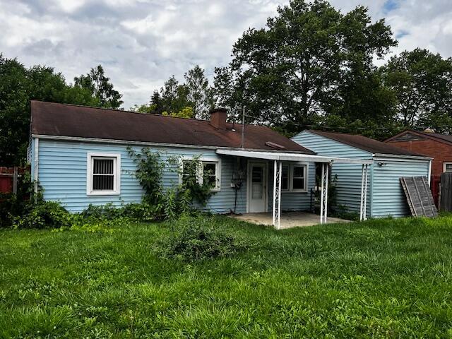 284 Old Village Rd, Columbus, OH 43228 - back of property featuring a patio, a lawn, and a chimney