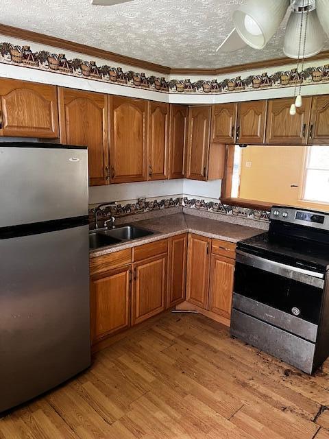 284 Old Village Rd, Columbus, OH 43228 - kitchen featuring appliances with stainless steel finishes, brown cabinetry, and light wood finished floors
