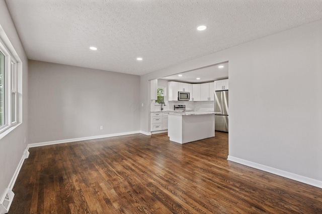 4256 Eleanor Ave, Grove City, OH 43123 - unfurnished living room featuring dark wood-style floors, a textured ceiling, and recessed lighting