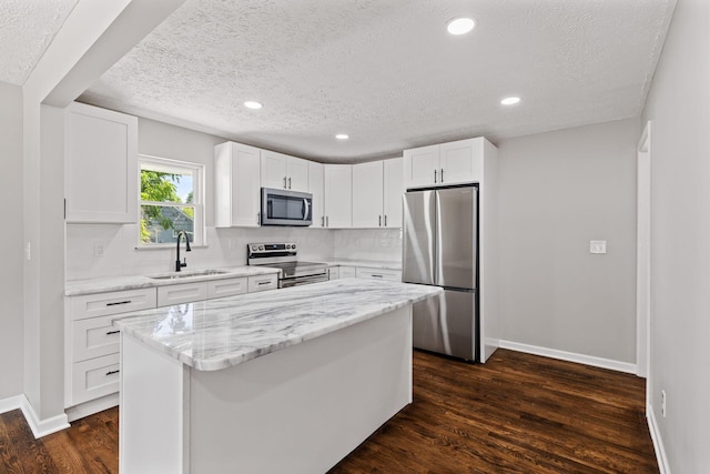 4256 Eleanor Ave, Grove City, OH 43123 - kitchen featuring stainless steel appliances, a textured ceiling, dark wood finished floors, white cabinetry, and tasteful backsplash