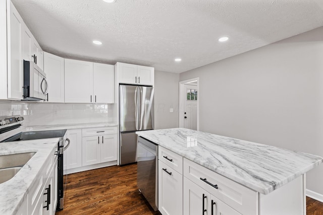 4256 Eleanor Ave, Grove City, OH 43123 - kitchen featuring appliances with stainless steel finishes, dark wood-type flooring, decorative backsplash, recessed lighting, and a kitchen island