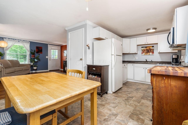 5950 Ambleside Dr, Columbus, OH 43229 - kitchen with freestanding refrigerator, stone finish floors, white cabinetry, and open floor plan