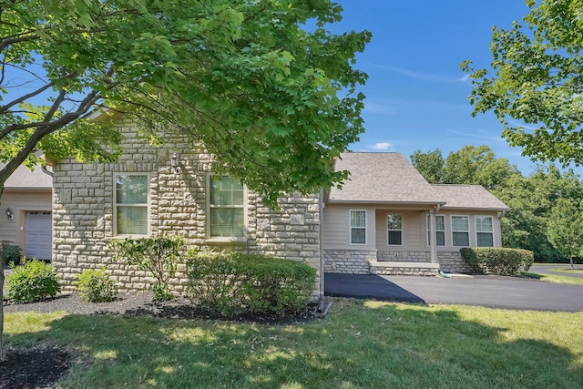 4887 Rays Cir, Dublin, OH 43016 - view of front of house with stone siding, a front yard, and a shingled roof