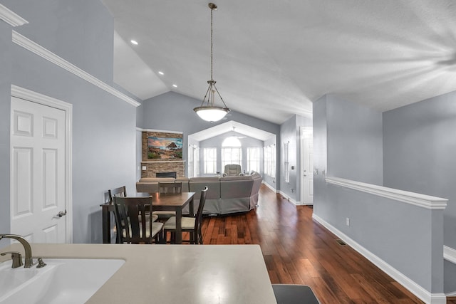 4887 Rays Cir, Dublin, OH 43016 - dining room with vaulted ceiling, dark wood-style flooring, a fireplace, and recessed lighting