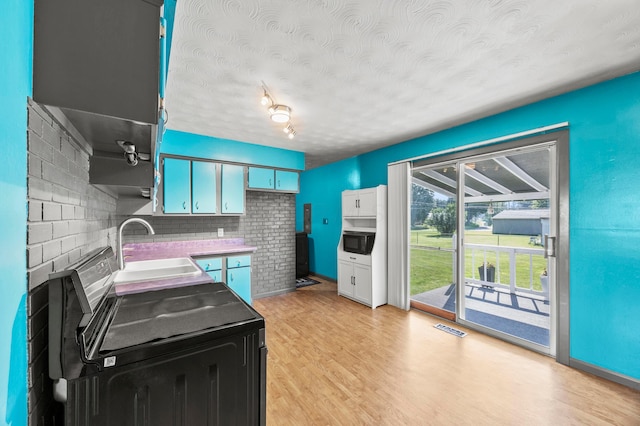 94 Fox Chase Dr, Newark, OH 43055 - kitchen featuring black microwave, a textured ceiling, decorative backsplash, light wood-style flooring, and electric stove
