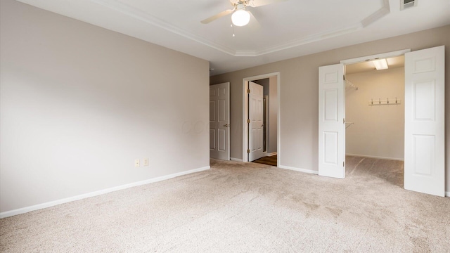 733 Windsor Ln, Heath, OH 43056 - unfurnished bedroom with carpet, a walk in closet, a tray ceiling, and ceiling fan
