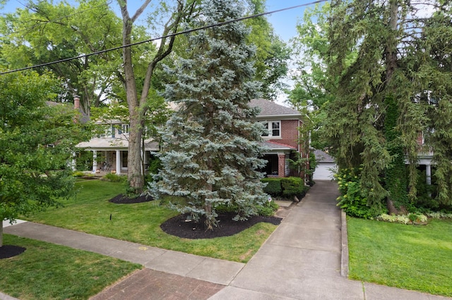 99 E N Broadway St, Columbus, OH 43214 - view of property hidden behind natural elements featuring a front yard, brick siding, and a garage