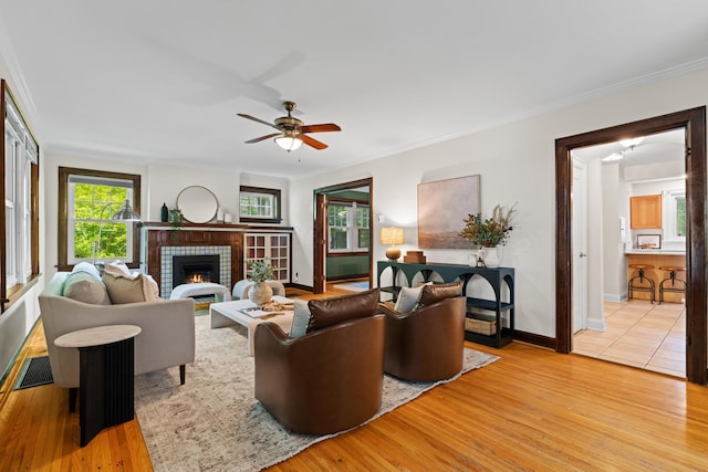 99 E N Broadway St, Columbus, OH 43214 - living room featuring light wood-type flooring, ornamental molding, a brick fireplace, and ceiling fan