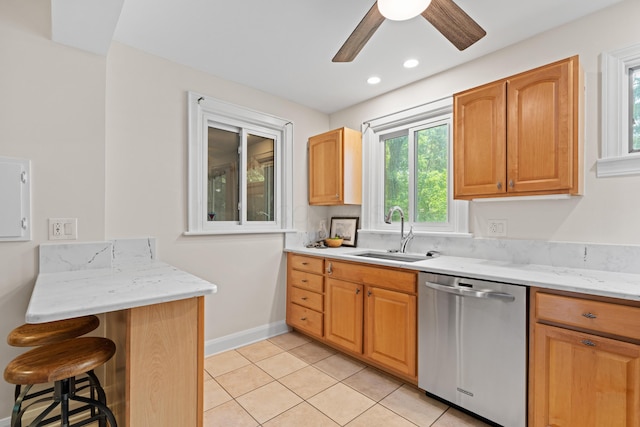 99 E N Broadway St, Columbus, OH 43214 - kitchen featuring stainless steel dishwasher, ceiling fan, light tile patterned flooring, a kitchen breakfast bar, and light stone countertops
