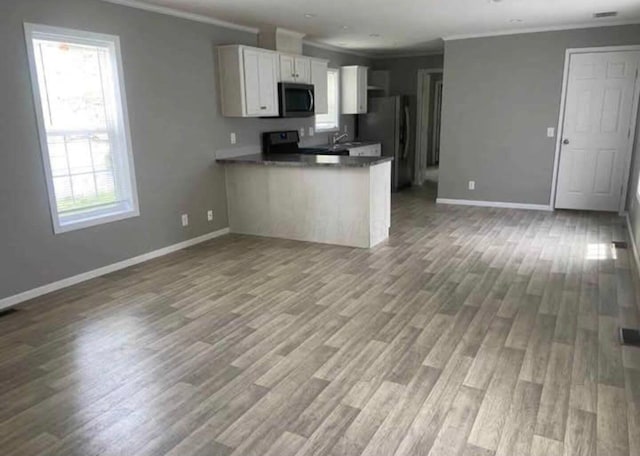 1330 Hanover Rd Unit 507, Delaware, OH 43015 - kitchen with stainless steel microwave, freestanding refrigerator, open floor plan, crown molding, and white cabinetry