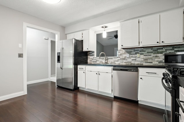 5975 Meadowsglen Dr, Dublin, OH 43017 - kitchen with stainless steel appliances, dark countertops, decorative backsplash, a ceiling fan, and white cabinetry