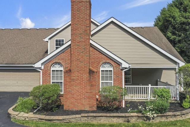 892 Shelbourne Pl, Newark, OH 43055 - view of home's exterior featuring brick siding, driveway, a shingled roof, an attached garage, and a chimney