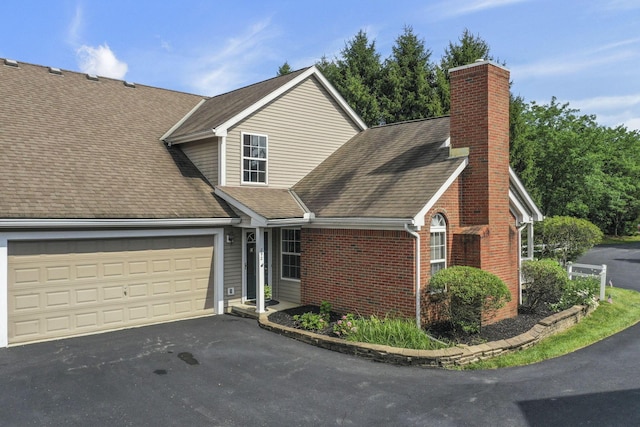 892 Shelbourne Pl, Newark, OH 43055 - view of front of home featuring a chimney, an attached garage, roof with shingles, asphalt driveway, and brick siding
