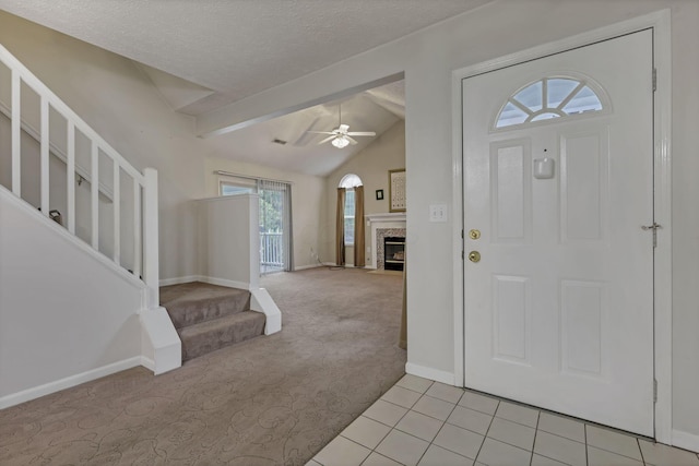 892 Shelbourne Pl, Newark, OH 43055 - entrance foyer featuring ceiling fan, light colored carpet, stairway, a fireplace, and light tile patterned floors