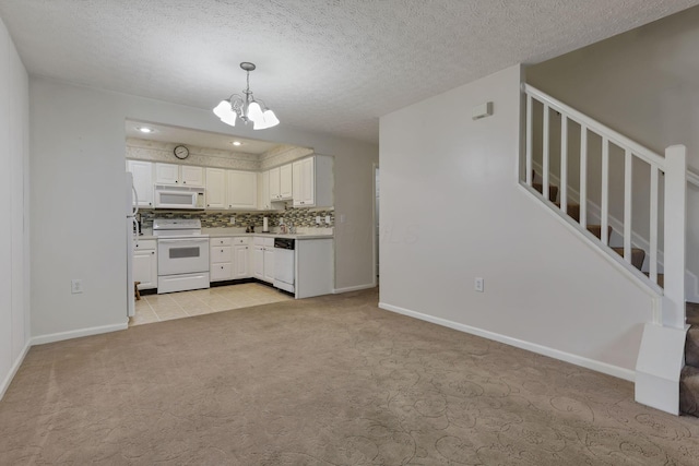 892 Shelbourne Pl, Newark, OH 43055 - kitchen featuring white appliances, light carpet, a chandelier, white cabinetry, and decorative backsplash