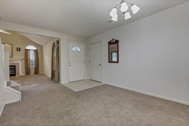 892 Shelbourne Pl, Newark, OH 43055 - carpeted entryway featuring a ceiling fan, a chandelier, a fireplace, vaulted ceiling, and a textured ceiling