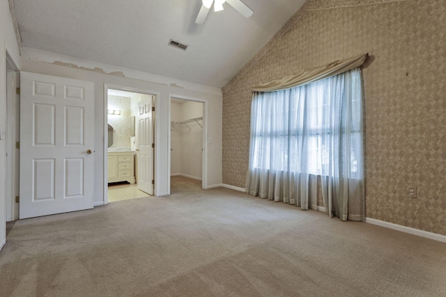 892 Shelbourne Pl, Newark, OH 43055 - unfurnished bedroom with wallpapered walls, vaulted ceiling, carpet, ensuite bath, and a walk in closet