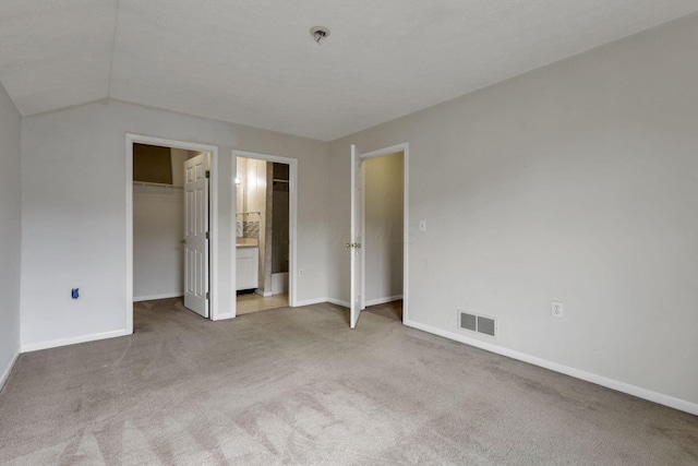 892 Shelbourne Pl, Newark, OH 43055 - unfurnished bedroom with carpet flooring, a spacious closet, vaulted ceiling, and connected bathroom