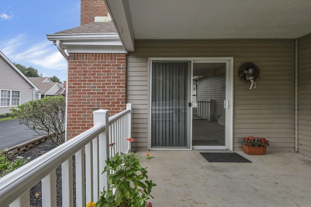 892 Shelbourne Pl, Newark, OH 43055 - view of exterior entry with a balcony, brick siding, and a chimney