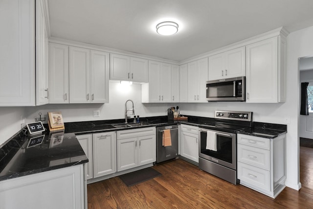 54 Barry Rd SW, Reynoldsburg, OH 43068 - kitchen with appliances with stainless steel finishes, white cabinets, dark wood-type flooring, and dark stone counters