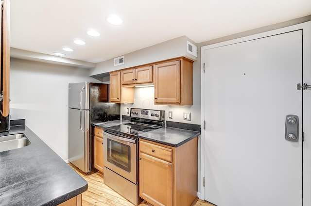 444 N Front St Unit 312, Columbus, OH 43215 - kitchen featuring appliances with stainless steel finishes, dark countertops, light wood-type flooring, and recessed lighting