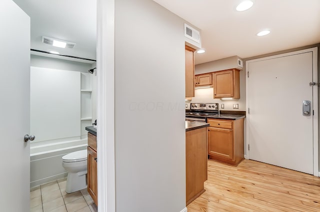 444 N Front St Unit 312, Columbus, OH 43215 - kitchen featuring dark countertops, stainless steel electric stove, recessed lighting, and light wood-style flooring