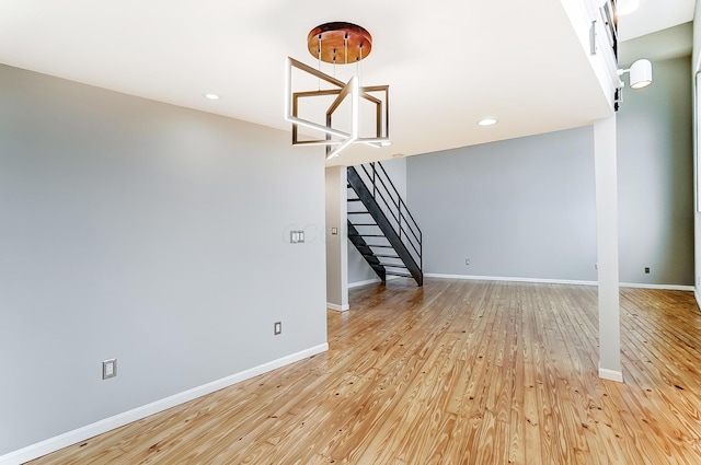 444 N Front St Unit 312, Columbus, OH 43215 - unfurnished living room with light wood finished floors, stairway, a chandelier, and recessed lighting