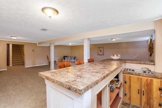 3251 Old Mill Rd NE, Lancaster, OH 43130 - kitchen with open floor plan, a textured ceiling, light countertops, light colored carpet, and a peninsula
