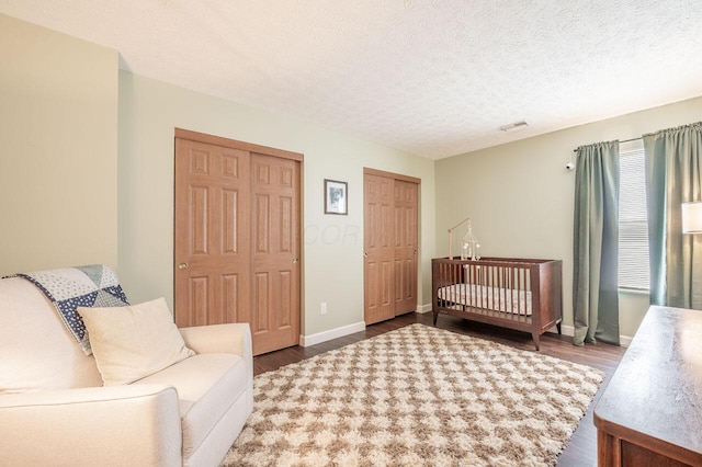 2621 Edencreek Ln, Columbus, OH 43207 - bedroom with wood finished floors, two closets, and a textured ceiling