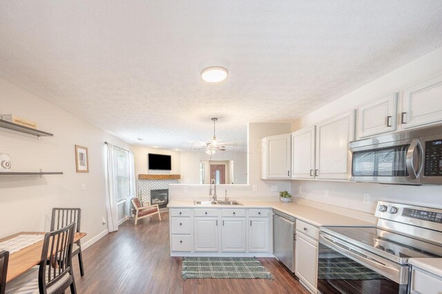 2621 Edencreek Ln, Columbus, OH 43207 - kitchen with stainless steel appliances, a textured ceiling, light countertops, a ceiling fan, and dark wood-style flooring