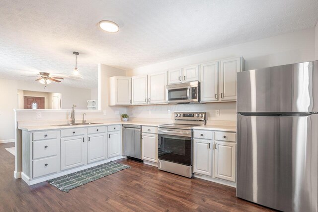 2621 Edencreek Ln, Columbus, OH 43207 - kitchen with appliances with stainless steel finishes, dark wood-style floors, light countertops, and a textured ceiling
