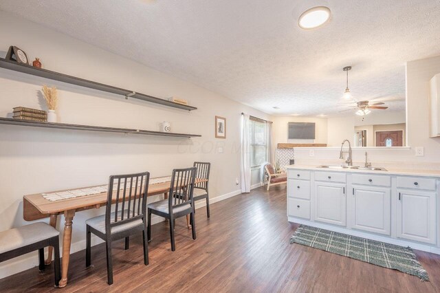 2621 Edencreek Ln, Columbus, OH 43207 - kitchen featuring a textured ceiling, a ceiling fan, dark wood-style flooring, light countertops, and a peninsula