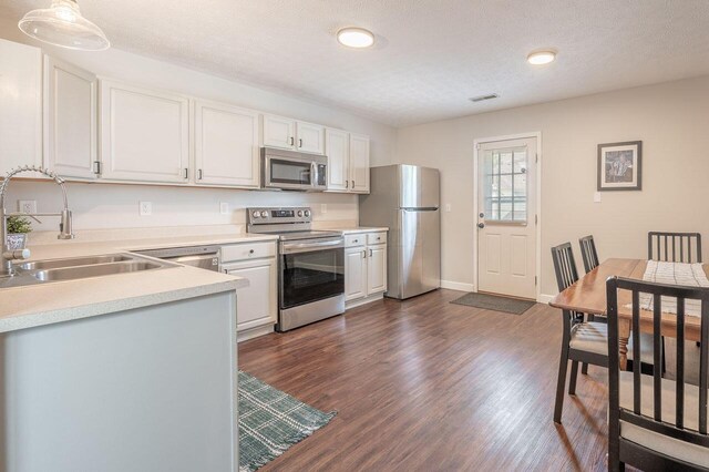 2621 Edencreek Ln, Columbus, OH 43207 - kitchen featuring stainless steel appliances, dark wood-type flooring, light countertops, white cabinets, and recessed lighting