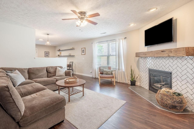 2621 Edencreek Ln, Columbus, OH 43207 - living area featuring a textured ceiling, dark wood-type flooring, a glass covered fireplace, and a ceiling fan
