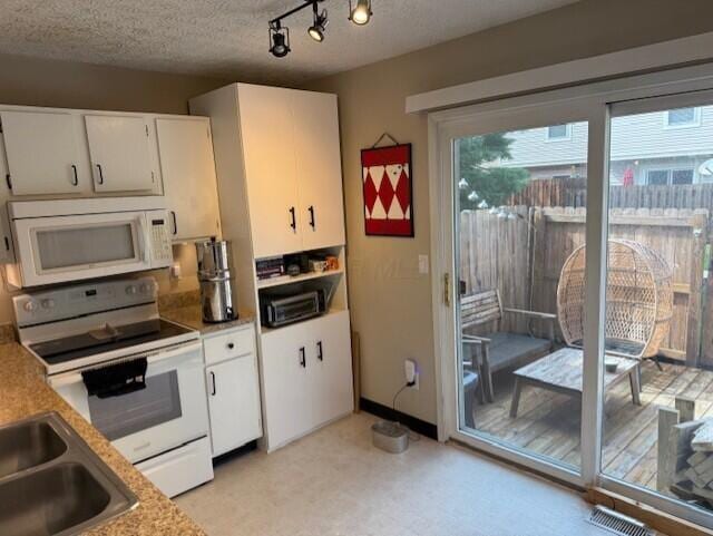 796 Cap Ln Unit 21C, Columbus, OH 43085 - kitchen featuring white appliances, white cabinetry, light floors, light countertops, and a textured ceiling